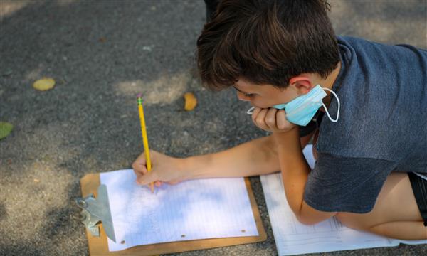 student writes on clipboard